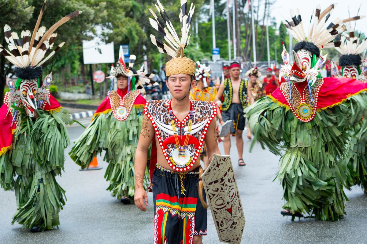Dayak warriors in traditional dress parade through Borneo streets