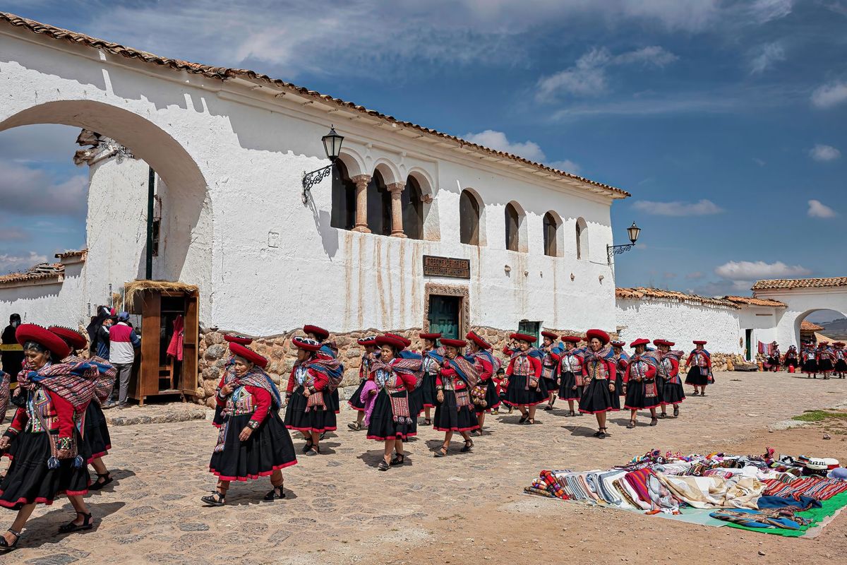 Women in traditional dress gather at Chinchero's colonial plaza