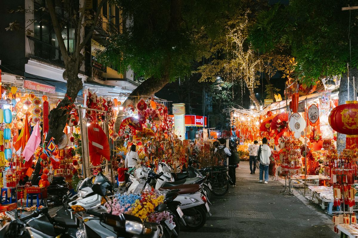Vibrant night market scene in the Old Quarter, filled with colourful lanterns and busy shoppers.